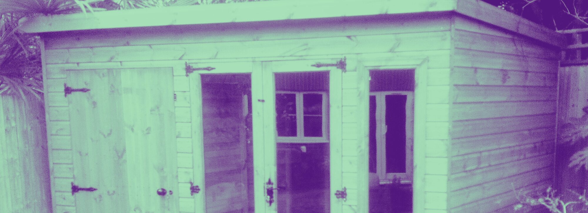 A heavily filtered photo of a wooden studio workshop with glass windows and doors.