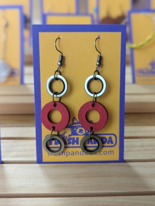 A close up of earrings on a display card - the earrings consist of three circles in a dangly style