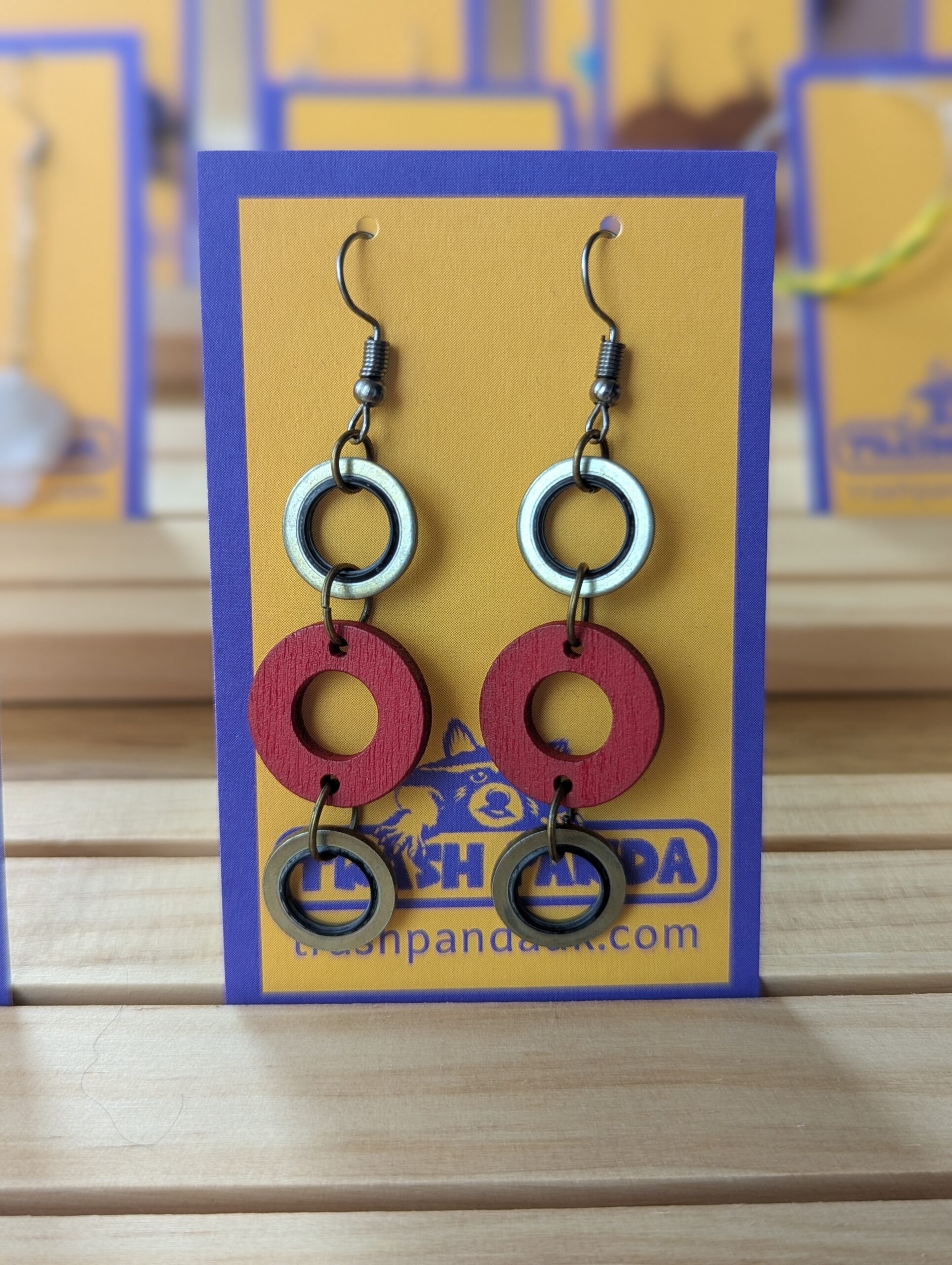 A close up of earrings on a display card - the earrings consist of three circles in a dangly style